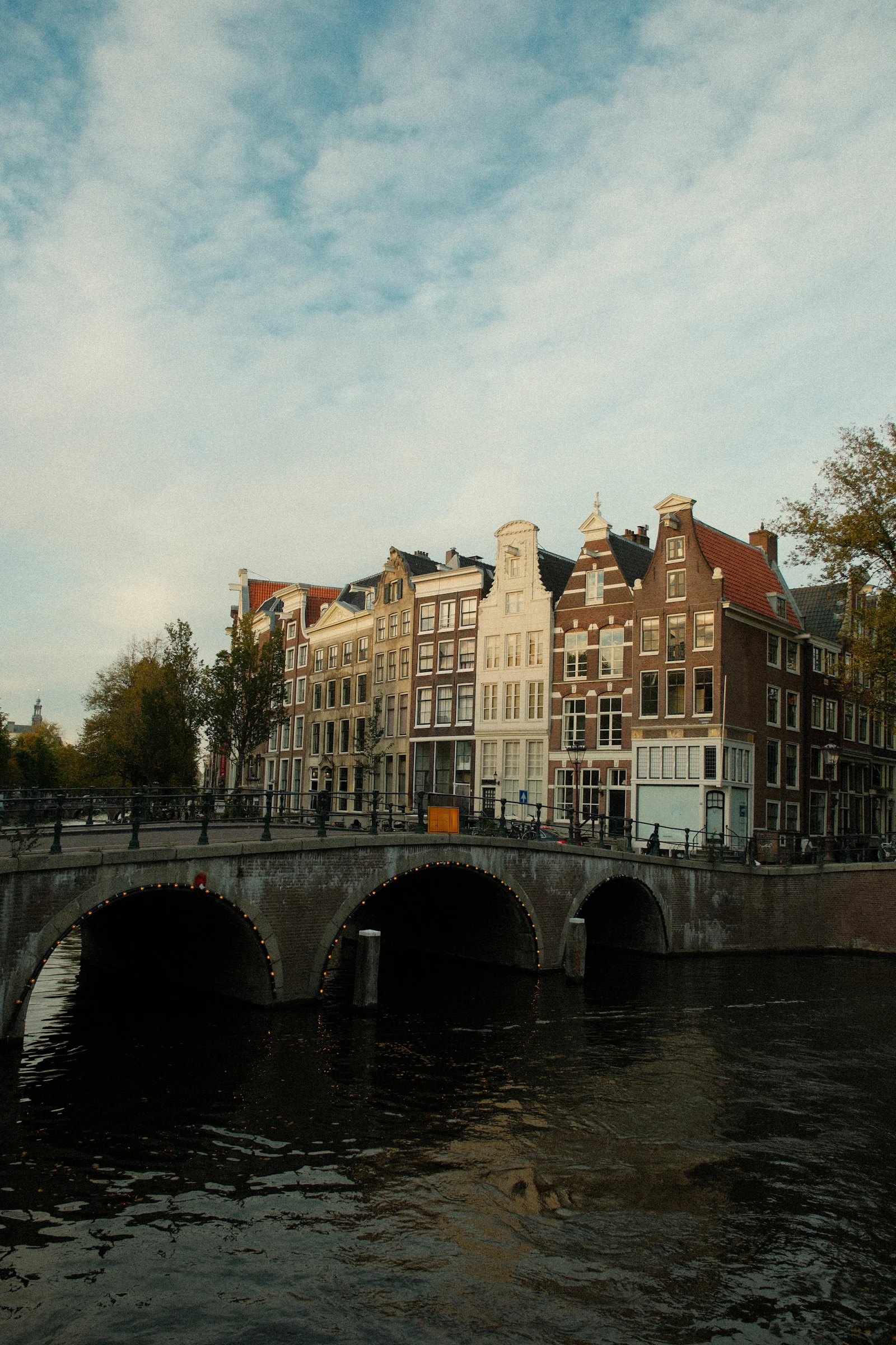Quiet canal with historic buildings and bridge in Amsterdam